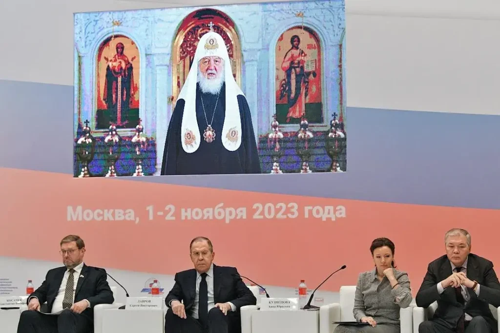Онлайн-выступление патриарха Кирилла в ноябре 2023 на конференция «Укрепление традиционных духовно-нравственных ценностей — залог единства российских соотечественников» в Москве. Внизу слева направо: зампред Совета Федерации России Константин Косачев, министр иностранных дел России Сергей Лавров, зампред Госдумы России Анна Кузнецова и Леонид Калашников. Фото: Евгений Разумный/Коммерсантъ.