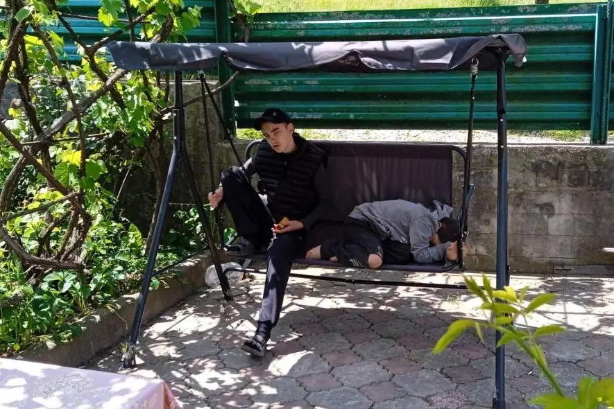 Сыновья Ольги Мазур Саша (слева) и Вова (дома) рядом с домом качаются на качели. Фото: личный архив.