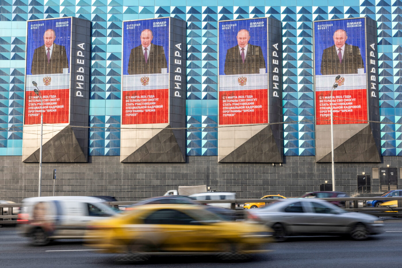 Фото Владимира Путина и цитата из его послания Федеральному Собранию, в Москве